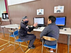 講師が受講者にマンツーマンで指導するドローン操縦講習の様子