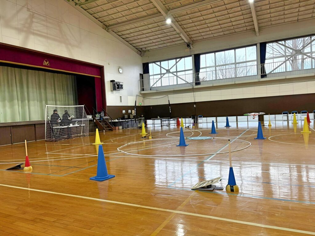 「実技審査」高度1.5m上昇後ホバリング・8の字飛行（時計周り、反時計回り）を2周。最も難操舵です