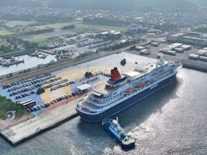 港に停泊する大型客船を上空からドローンで撮影し、岸壁や周辺施設の全体像を捉えた空撮画像