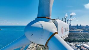 海沿いの工業地帯に設置された大型風力発電設備をドローンで上空から撮影した点検用空撮画像