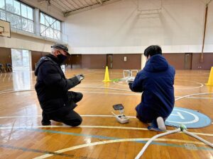 二等無人航空機操縦士の修了審査検定で飛行前点検を行う受講生と検定官｜国家資格対応ドローンスクール実地試験風景